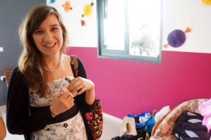 Smiling woman holding a small object in a bright room