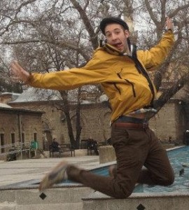 Young man jumping joyfully in a yellow jacket