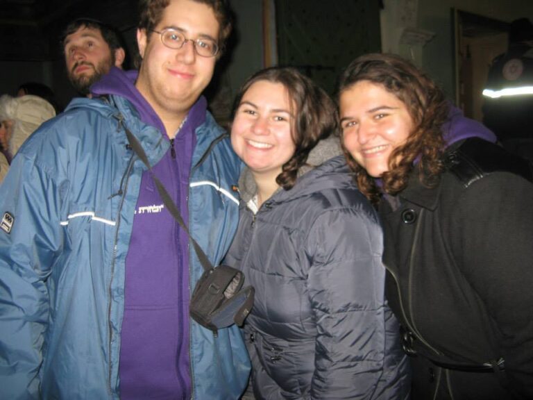 Group of young people in jackets smiling at night