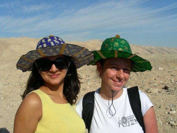 Two women in colorful sun hats in the desert