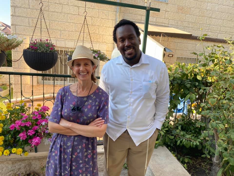 Woman in a sun hat and man standing in a garden