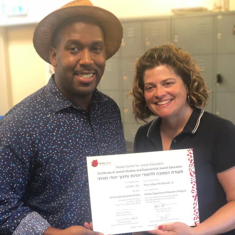 Man in a hat and a woman holding a certificate