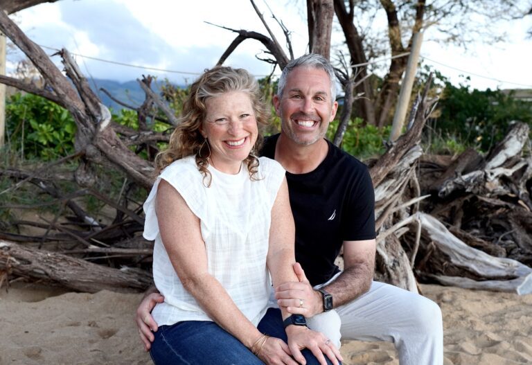 Jenny Solomon and Eric Solomon sitting on a beach log