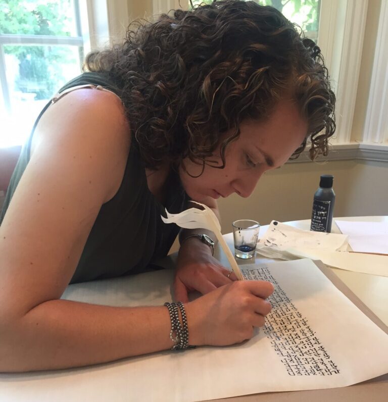 Rabbi Myra Meskin Gurin writing with a quill