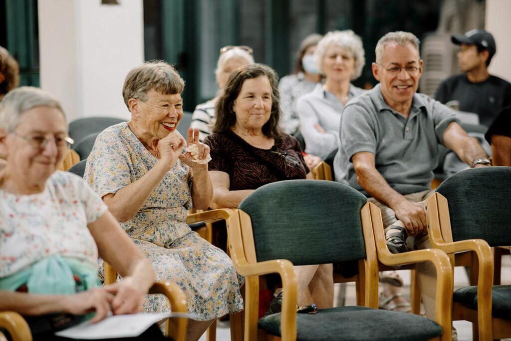 Smiling seniors seated in rows at an event